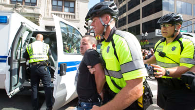 En motdemonstrant förs iväg av polisen under demonstrationen i Boston.