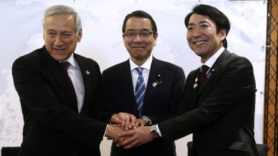 Japans handelsrepresentanter Takao Ochi och Toshinao Nakagawa skakar hand med Chiles utrikesminister Heraldo Muñoz efter att TPP-avtalet undertecknades i Chile