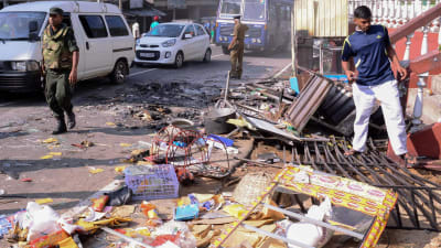 polis i Sri Lanka utanför en förstörd butik i distriktet Kandy 6.3.2018.