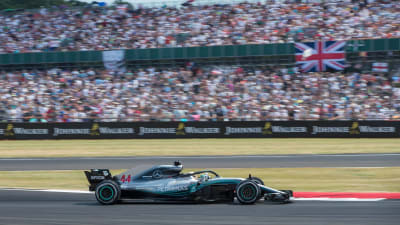 Lewis Hamilton kör förbi en välfylld läktare.