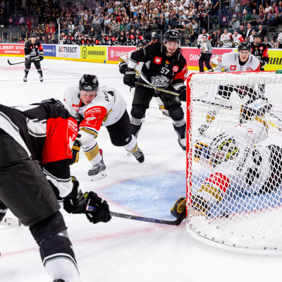 Will Acton petar in segerpucken bakom Jussi Rynnäs.