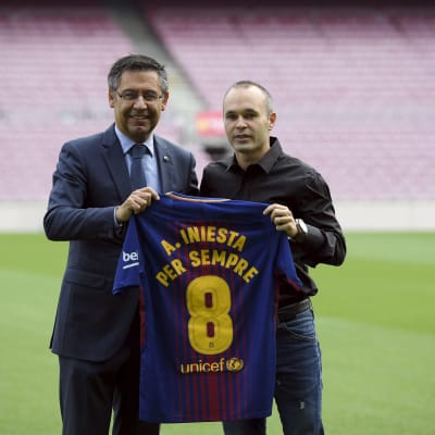Andres Iniesta håller upp sin speltröja tillsammans med klubbens president