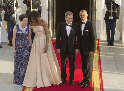 Jenni Haukio juttelee Michelle Obaman kanssa punaisella matolla Washingtonin Valkoisella talolla. Kuvassa myös presidentit Sauli Niinistö ja Barack Obama.