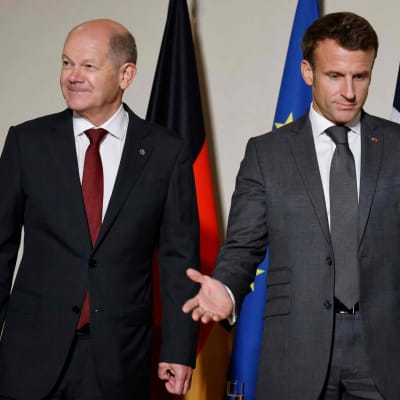 Tysklands förbundskansler Olaf Scholz och Frankrikes president Emmanuel Macron står brevid varandra men tittar åt olika håll.