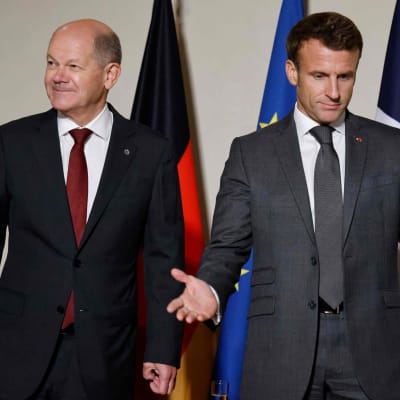 Tysklands förbundskansler Olaf Scholz och Frankrikes president Emmanuel Macron står brevid varandra men tittar åt olika håll.