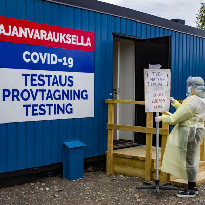Tornion kaupungin koronatestauksen työntekijä siirtää kylttiä.