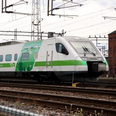 Ett grönvitt Pendolino-tåg på en bangård.