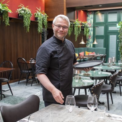 Mika Gehör dukar fram glas på restaurangbordet.
