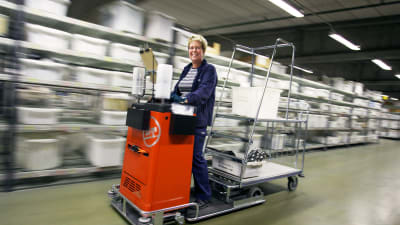 Kvinna som kör truck i en lagerhall