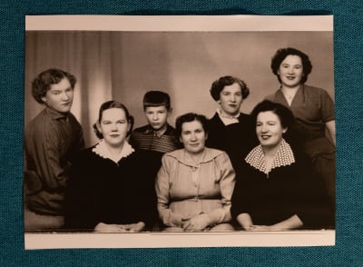 50-luvun valokuvassa poseeraa äiti kuuden lapsensa kanssa. Viisi tytärtä näyttävät aikuisilta, poika on näitä selvästi nuorempi.