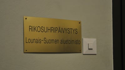 En skylt i guld med texten Rikosuhripäivystys som finns utanför brottsofferjouren i Åbo.