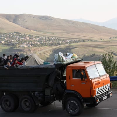 En lastbil med flyktingar ombord åker på en väg.