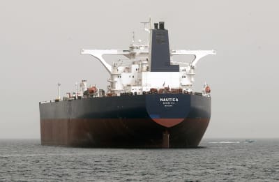 Fartyg med texten "Nautica" på fören. Grå dag.
