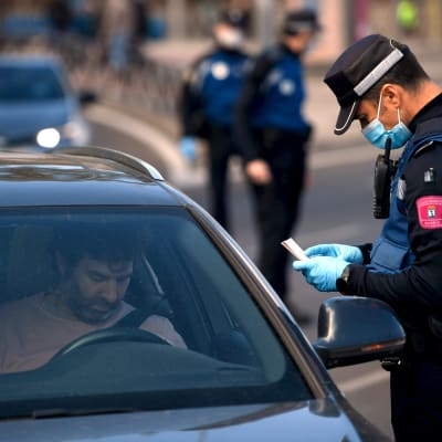 En polis granskar hur människor rör sig i Madrid 3.10.2020