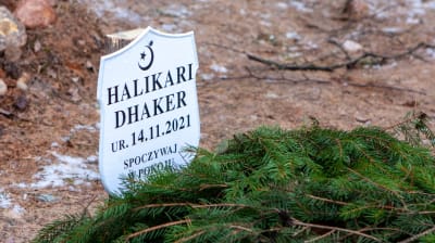 En skylt vid en granrisprydd grav med texten "HALIKARI DHAKER ur. 14.11.2021".