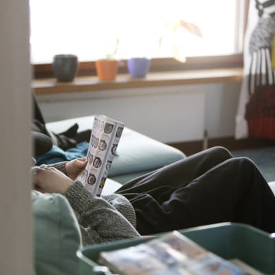 Barn sitter och läser i soffa