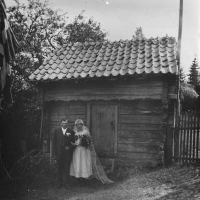 Ahvenanmaalainen hääpari aitan edustalla (1880-1920)