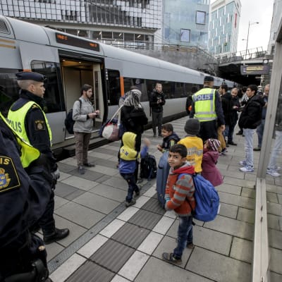 Svensk polis kontrollerar resenärer i Malmö.