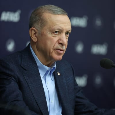 Recep Tayyip Erdogan står vid ett talarpodium och pratar.