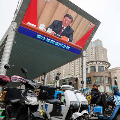 Xi Jinpingin puheen pitämistä näytetään suurella näytöllä katukuvassa.