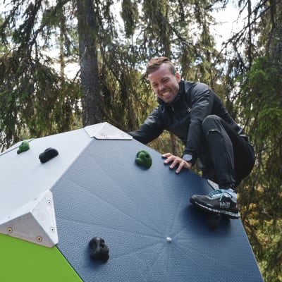 Joakim Träskelin klättrar på klätterkub i skogsmiljö.