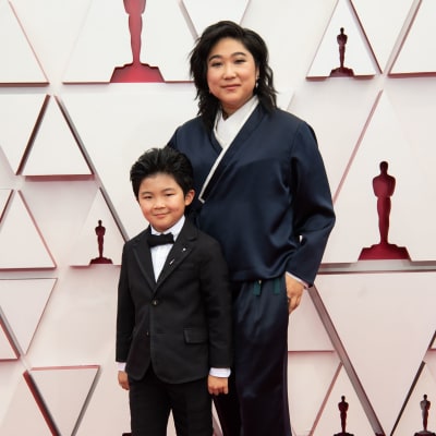 Barnskådespelaren Alan S. Kim från filmen Minari på röda mattan med producenten Christina Oh. 