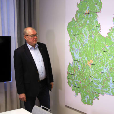 Etelä-Savon maakuntajohtaja Pentti Mäkinen työhuoneessaan. Esillä Etelä-Savon uusi kartta, jossa ei enää ole Joroista tai Heinävettä.