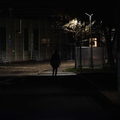 Tumma hahmo kävelee ulkona marraskuussa 2020.