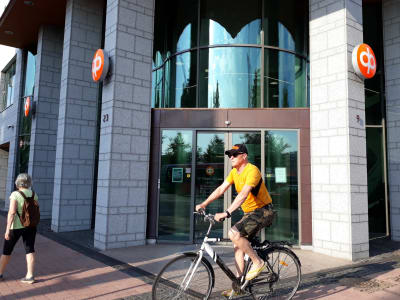 Man cyklar förbi dörren till en bank.
