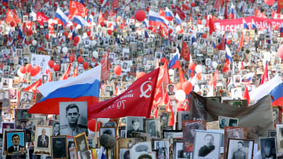 Deltagare i minnesmarschen på Röda torget i Moskva under Segerdagen bär på fotografier av anhöriga som deltog i andra världskriget.