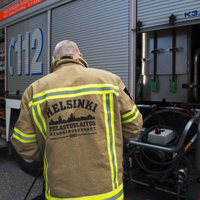 palomies huoltaa paloautoa Helsingin keskuspelastusaseman pihalla