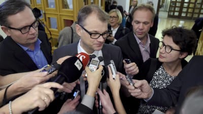 Statsminister Juha Sipilä omringad av journalister.