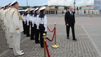 Vladimir Putin promenerar förbi en hedersvakt.