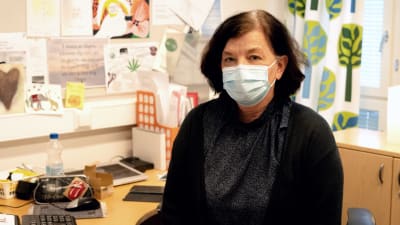 Skolhälsovårdare Antonina Carlberg, en kvinna med brunt kort hår, iklädd munskydd, tittar mot kameran.