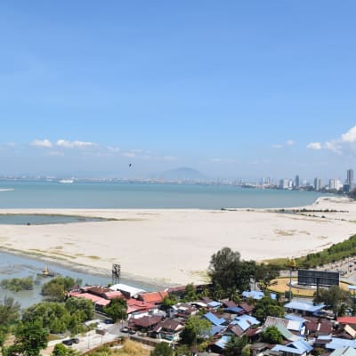 Sand invid havet i Georgetown i Malaysia. Sand har dumpats i havet för att göra stadens areal större.