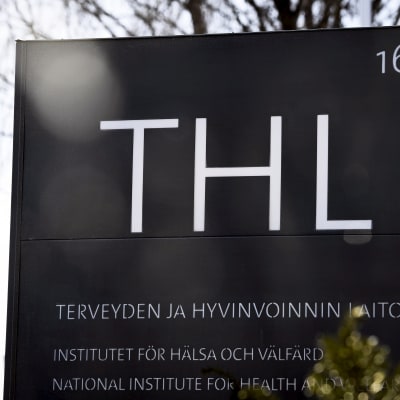 En svart skylt med texten THL och Institutet för hälsa och välfärd.