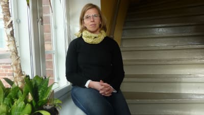 Forskaren Mia Heikkilä sitter vid ett fönster