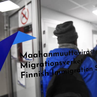 En person stiger in genom dörren till Migrationsverket