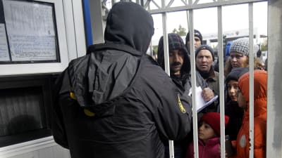 Flyktingar utanför migrationsmyndigheten i Athen för att söka asyl.