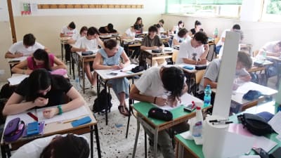 Studerande sitter i ett klassrum och avlägger ett prov.