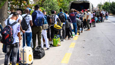 Flyktingar som köar till en buss på Lesbos