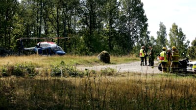 En polishelikopter, poliser, räddningspersonal och militärer nära platsen för Jas-haveriet i Blekinge den 21 augusti 2018
