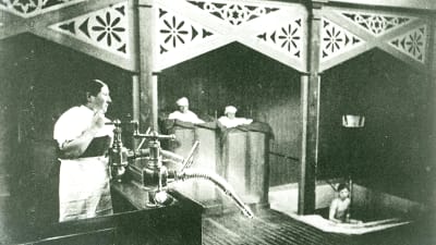 En gammal svart vit bild som visar duschen i badhuset i Hangö för över 100 år sedan.