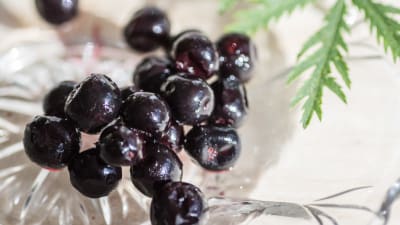 Pakastettuja variksenmarjoja lasilautasella