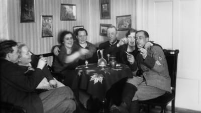 En svartvit bild på ett festande sällskap vid ett bord under förbudslagen.