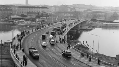 Ett foto av Hagnäs bro strax efter dess invigning 1961. Människor och bilar passerar åt båda hållen.