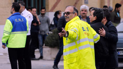 Räddningspersonal följer med anhöriga till passagerarna på det iranska olycksplanet.