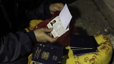 Den grekiska sjöbevakningen samlar in pass av syriska flyktingar på ön Kos