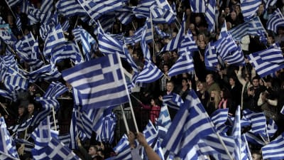 Greker viftar med falggor under valmöte inför det grekiska parlamentsvalet 25.1.2015