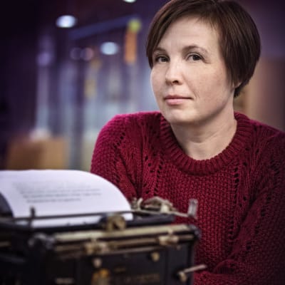 Författaren Karin Erlandsson vid en skrivmaskin.